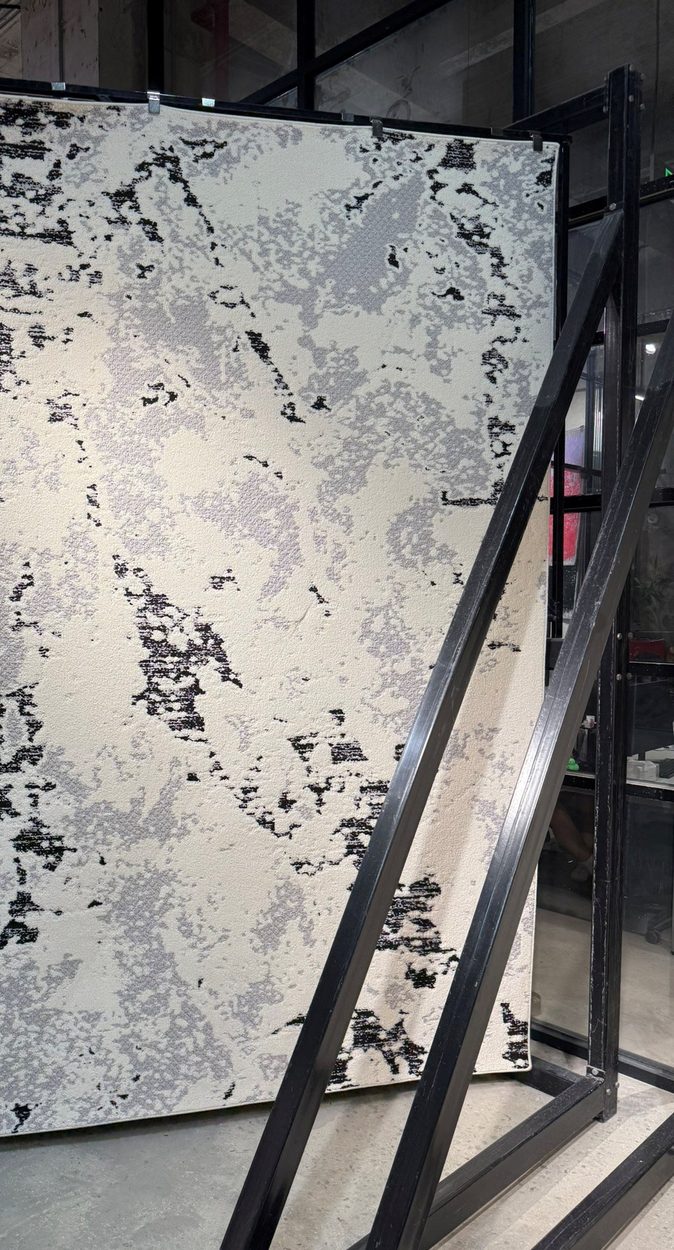 A large rug drawn out of a showroom swing-rack