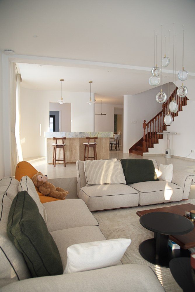 Sun across the sofas, the island and stair beyond