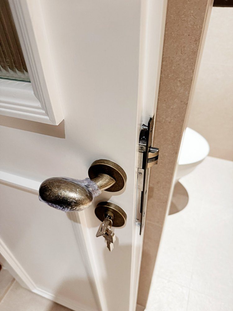 Aged brass door lever and escutcheon on a panelled door